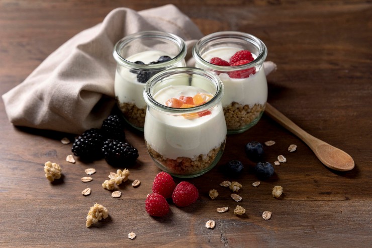 Vasetti di yogurt con frutta fresca e muesli su un tavolo 